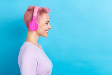 Side profile photo of cute girl wear trendy sweatshirt listen playlist in headphones look empty...