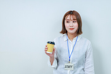 コーヒーを持った若い女性スタッフ