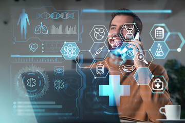 Handsome businessman working on laptop at office workplace in background. Using phone to read text, and send messages. Concept of medical education and insurance.