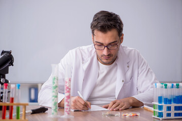 Young male chemist in front of white board