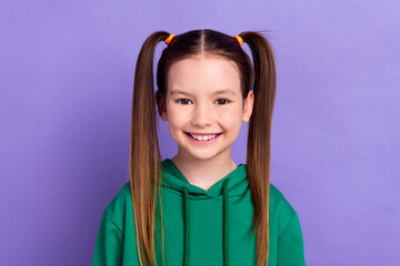 Portrait of lovely funny small girl wearing green hoody demonstrating toothy smile dentistry ad isolated purple color background