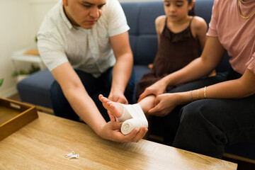 Parents putting a bandage on their child with an injury