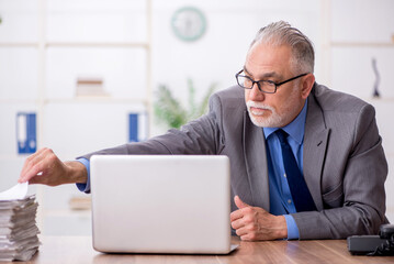 Old male employee working in the office