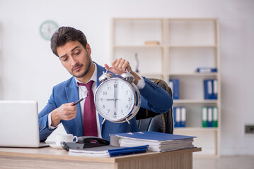 Young male employee in time management concept