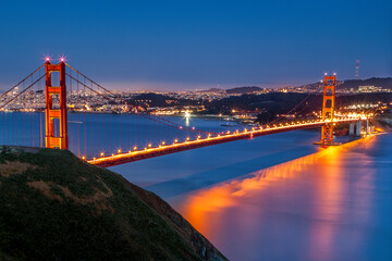 Golden Gate Bridge at dusk. he Golden Gate Bridge is a suspension bridge spanning the Golden Gate, the one-mile-wide (1.6 km) strait connecting San Francisco Bay and the Pacific Ocean.