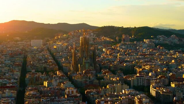 Aerial Shot of Bas&iacute;lica i Temple Expiatori de la Sagrada Fam&iacute;lia At Sunset. Avinguda de Gaud&iacute;, beautiful panorama. European cityscape. Mediterranean city. Aerial establishing shot of Barcelona. 