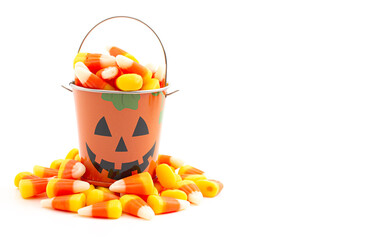 A Tin Pumpkin Jack O Lantern Bucket FIlled with Candy Corn on a White Background