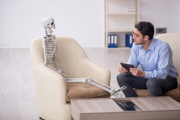 Young male psychologist meeting with skeleton
