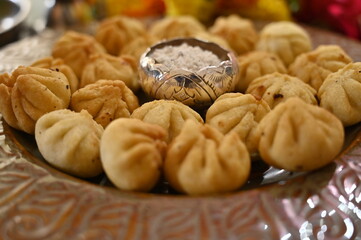 Beautiful Plate with the fresh fried Modak. Sweets for Lord Ganesha. Silver Bowl with coconut and sugar. Prasad for Lord Ganesha. Chaturthi festival Chaturdashi festival Visarjan Pooja. Diwali modak