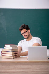 Young male student sitting in the classroom