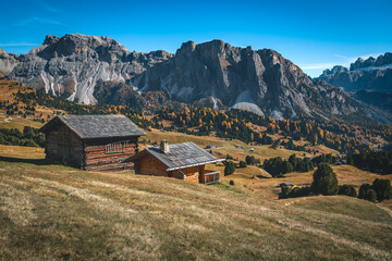 Log houses on the slope in the Dolomites, Italy