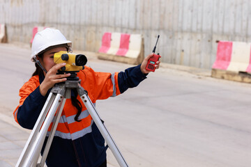Engineer use theodolite equipment for route surveying to build a bridge across the intersection to...
