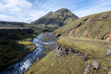 River amidst volcanic landscape of Fjallabak Nature Reserve in Icelandic highlands on sunny autumn afternoon..