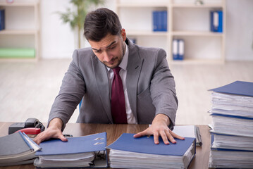 Young male employee and too much work in the office