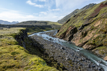 River amidst volcanic landscape of Fjallabak Nature Reserve in Icelandic highlands on sunny autumn afternoon..