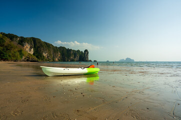 kayak boat on sand beach and sea blue sky to many people or person and tourists playing kayaking in water with mountain for summer holiday travel and vacation recreation at ao nang krabi in thailand