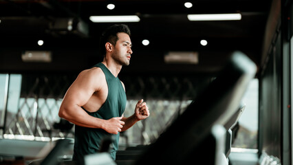 Fototapeta na wymiar Young Asian Man Running on Treadmill - Fitness Gym Exercise