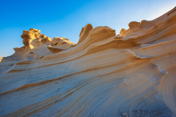 Desert eroded rock pattern with clear sky. Desert rock formation with erosion