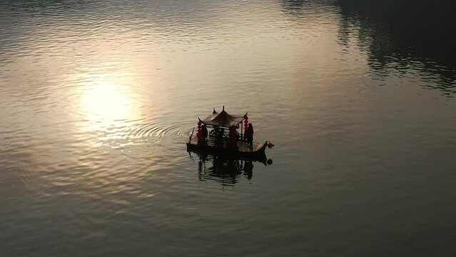 Asian chinese boat with reflection of the sun on a lake in Thailand. Aerial shot 