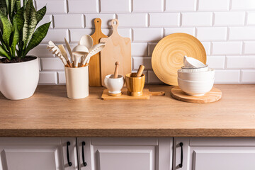 Fototapeta na wymiar Kitchen background with a set of various kitchen tools and utensils made of natural environmentally friendly materials. Eco style on a modern kitchen.