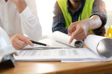 architect explaining client demand plan of construction on the table to contractor.