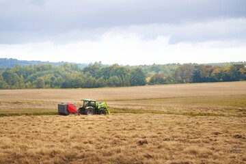 Obraz premium Agricultural machinery. Tractor Cultivating Fields at Sunset. Combine harvester at work. Agricultural industrial. Farming at Golden Hour.