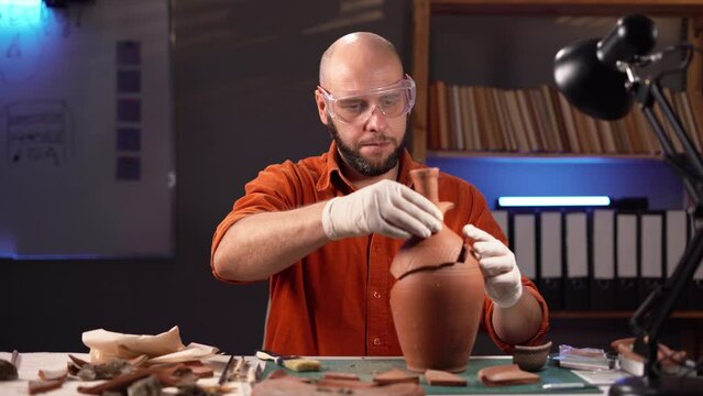 Archaeologist working in the office overtime at night. Study of ancient culture and civilization. Old clay amphora, ancient vessel. Excavation and archeology