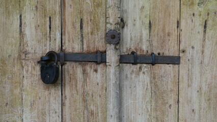 Padlock on old wooden gate