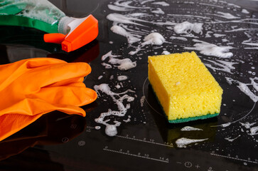 Cleaning the induction hob with a sponge.