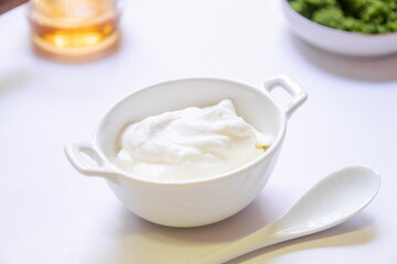 Greek yogurt and wolffia globosa in ceramic bowl isolated on white table background. Wolffia is the...