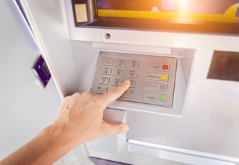 Young woman using the card for withdrawing the cash in the ATM