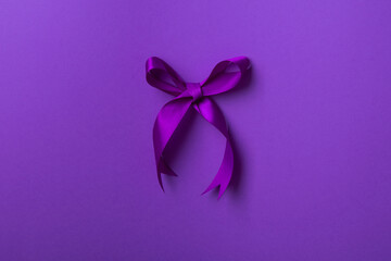 Purple bow ribbon isolated on purple background.