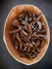 Dried carob pods close-up in a cork container.Isolated carob and carob background. - obrazy, fototapety, plakaty