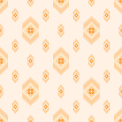 In this seamless pattern, orange flowers, petals stacked in gradient shades, arranged in a diamond frame around the frame decorated with small elongated ovals, on light orange background.
