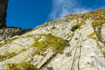 Via ferrata - Elements that facilitate crossing the more difficult part of the route, i.e. steps and buckles, and a steel rope for belaying from a lanyard. - 651835048