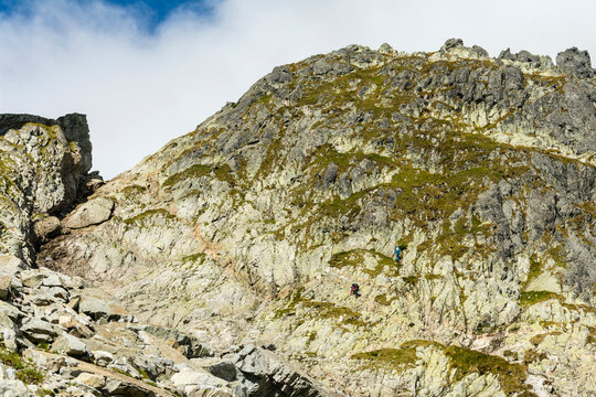 One tourist on the trail and the other on the nearby via ferrata to Priecne sedlo (Czerwona Lawka) in the Slovak High Tatras.
