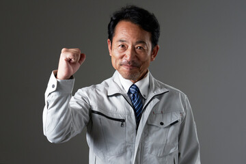 ガッツポーズをする作業員　黒背景