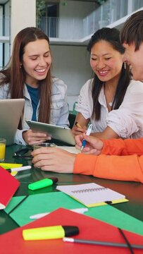 Secondary school students studying together with laptops at high school campus. Multiracial group of men and women classmates preparing final exams. Vertical 9:16 screen video. 