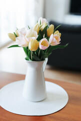 Spring tulips in a vase on the table. Spring holiday, home decor.