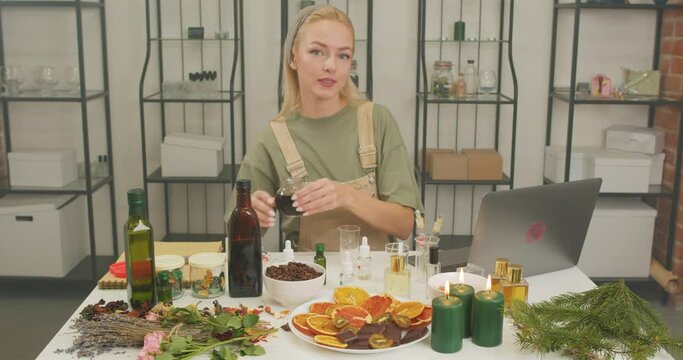 young woman mixing pouring different ingredients to make fantastic natural perfume slow motion. perfumer mixing fragrance and essential oil during process of blending nice scent for making perfume