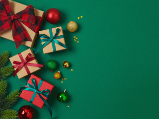 Merry Christmas and Happy New Year concept with gift box, ornaments and decorations on green background. Top view, flat lay