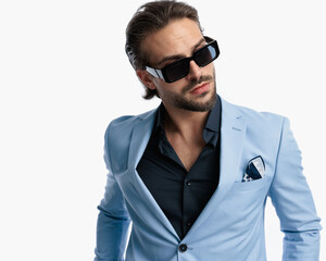 cool fashion guy with open collar shirt and sunglasses looking to side