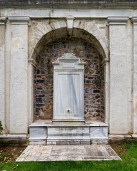 A beautiful white marble fountain located in the garden of the Mecidiye Pavilion, Istanbul, Turkey. The fountain is surrounded by a stone wall and features intricate carvings and designs