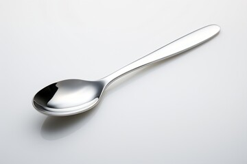 Silver spoon isolated on a grey background