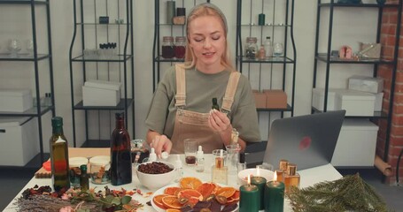 girl working on new perfume Blog by professional perfume industry analyst. Beauty skin care Young woman preparing perfume with pipette at table in workshop Essential oil dripping from pipette to