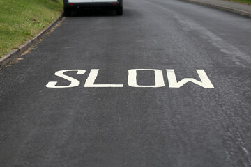 Sign "slow" painted on the road.