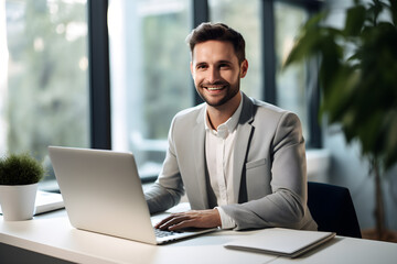 Fototapeta premium young handsome business man working with laptop in office
