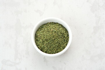 Fresh and dried herbs parsley leaves on wooden spoon
