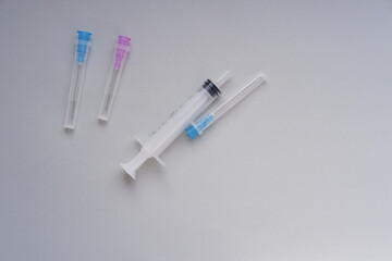 medical syringe with needles on a gray background.