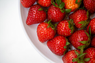 Fresh strawberries just picked from the tree on a white background